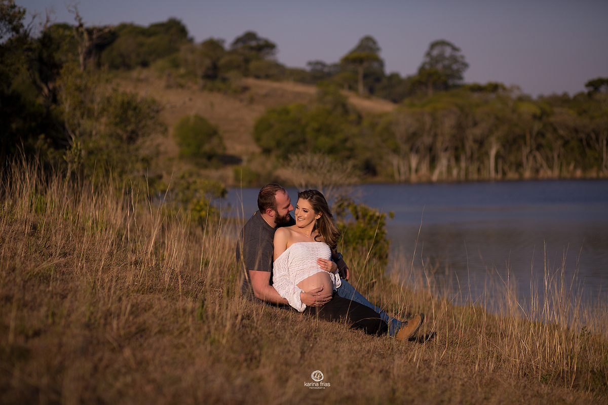 no ensaio externo, o pai cochicha no ouvido da gestante