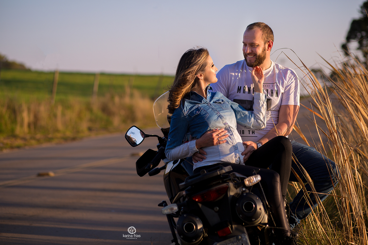 a gestante esta sentada na moto para suas fotos externas
