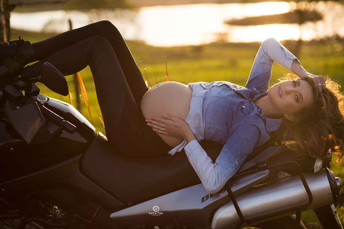 a modelo esta deitada na moto para a sessão de gestante