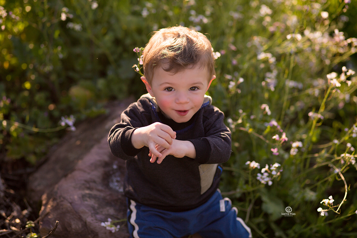o menino sorri para a fotografa de crianças de caxias do sul, karina frias