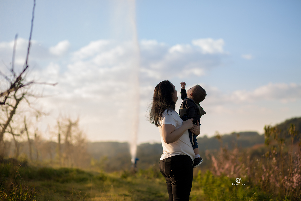 mae e filho olham a agua jorrar no ensaio externo