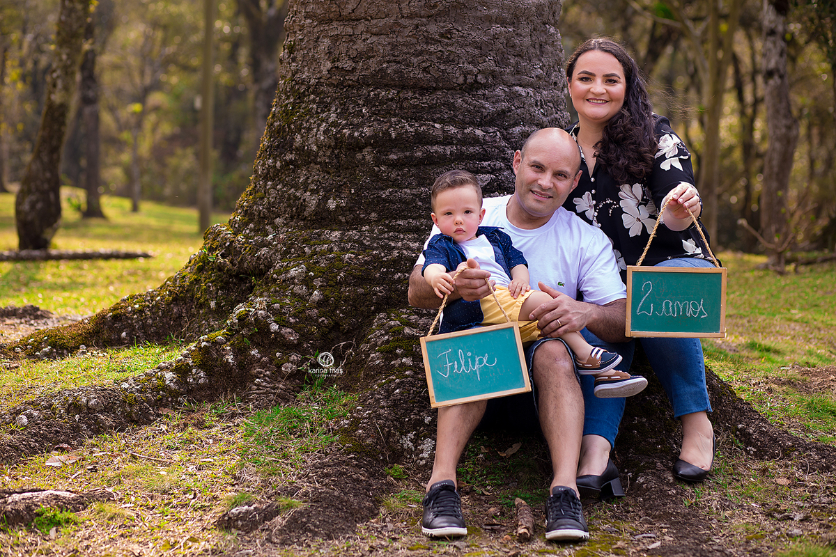 os pais seguram a plaquinha que mostra a idade do bebe