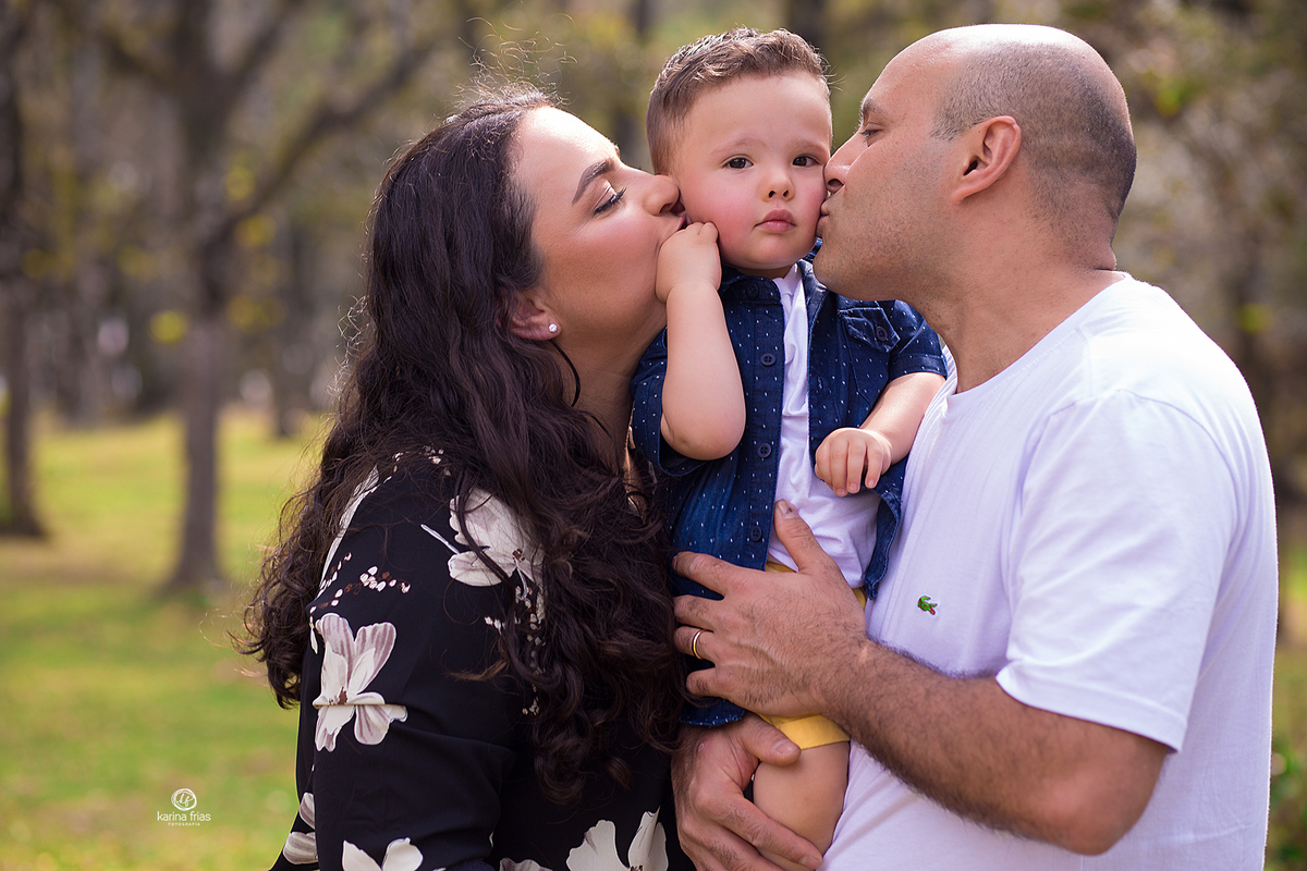 os pais beijam o bebe no ensaio externo