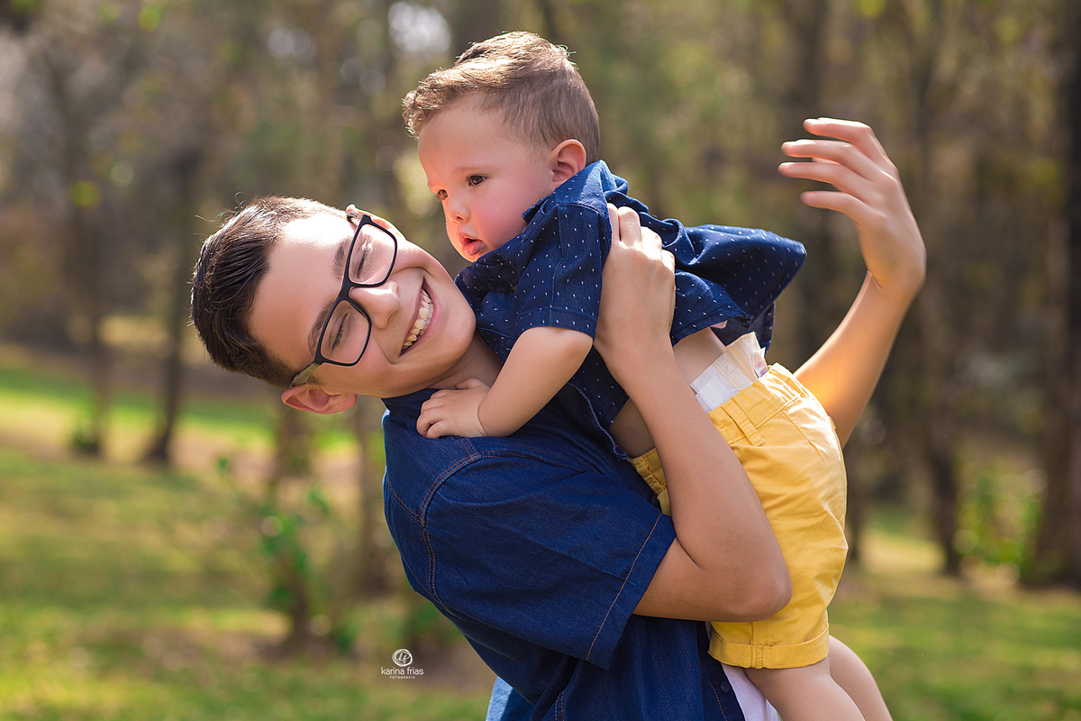 o irmao pega o bebe no colo durante ensaio de familia