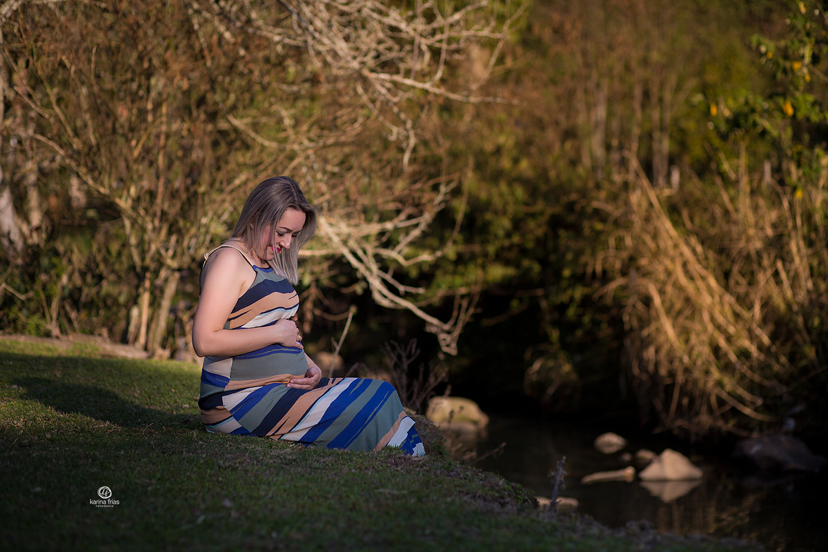 a gestante olha para a barriga no ensaio externo