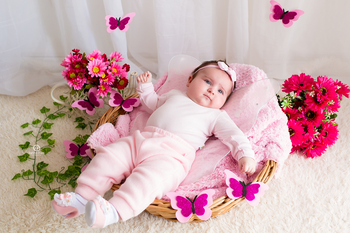 A menina esta vestida de borboleta para suas fotos mensais