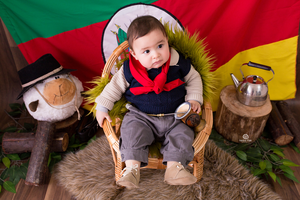 o menino esta sentado na cadeira de gaucho