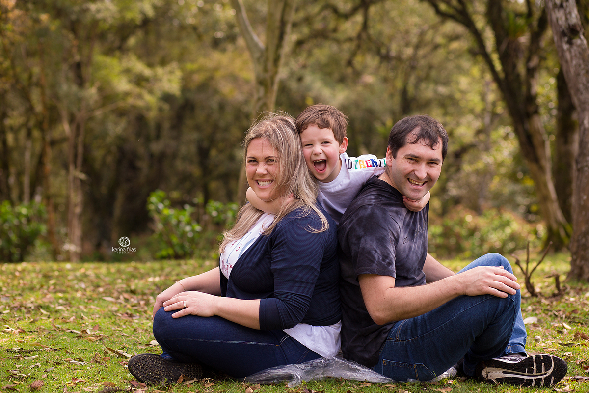 o menino abraça os pais enquanto a fotografa de caxias do sul registra o momento
