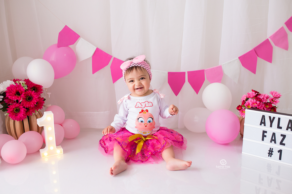 a menina esta posando para as fotos do seu primeiro aninho