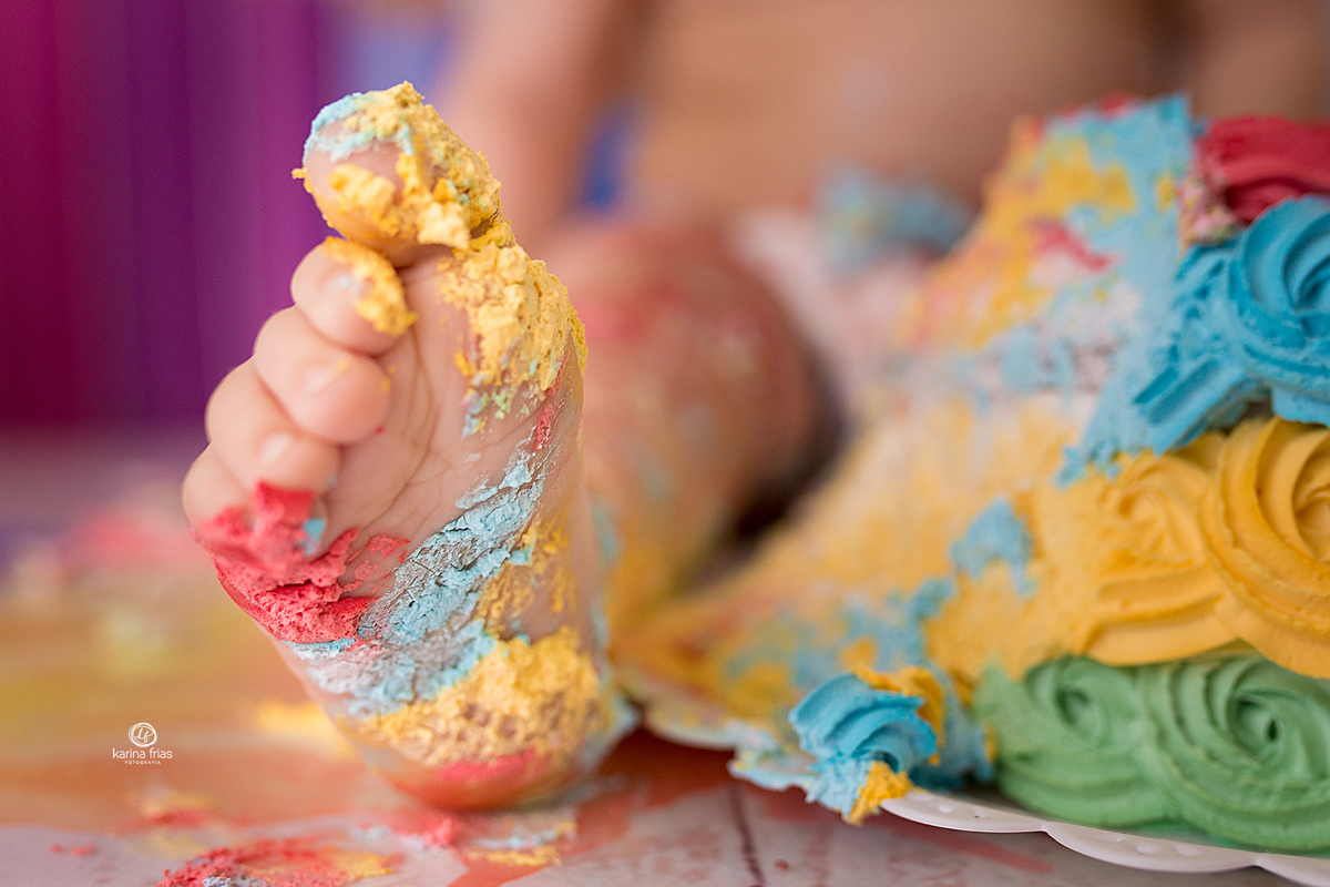 o menino lambuza o pé na sessão smash the cake