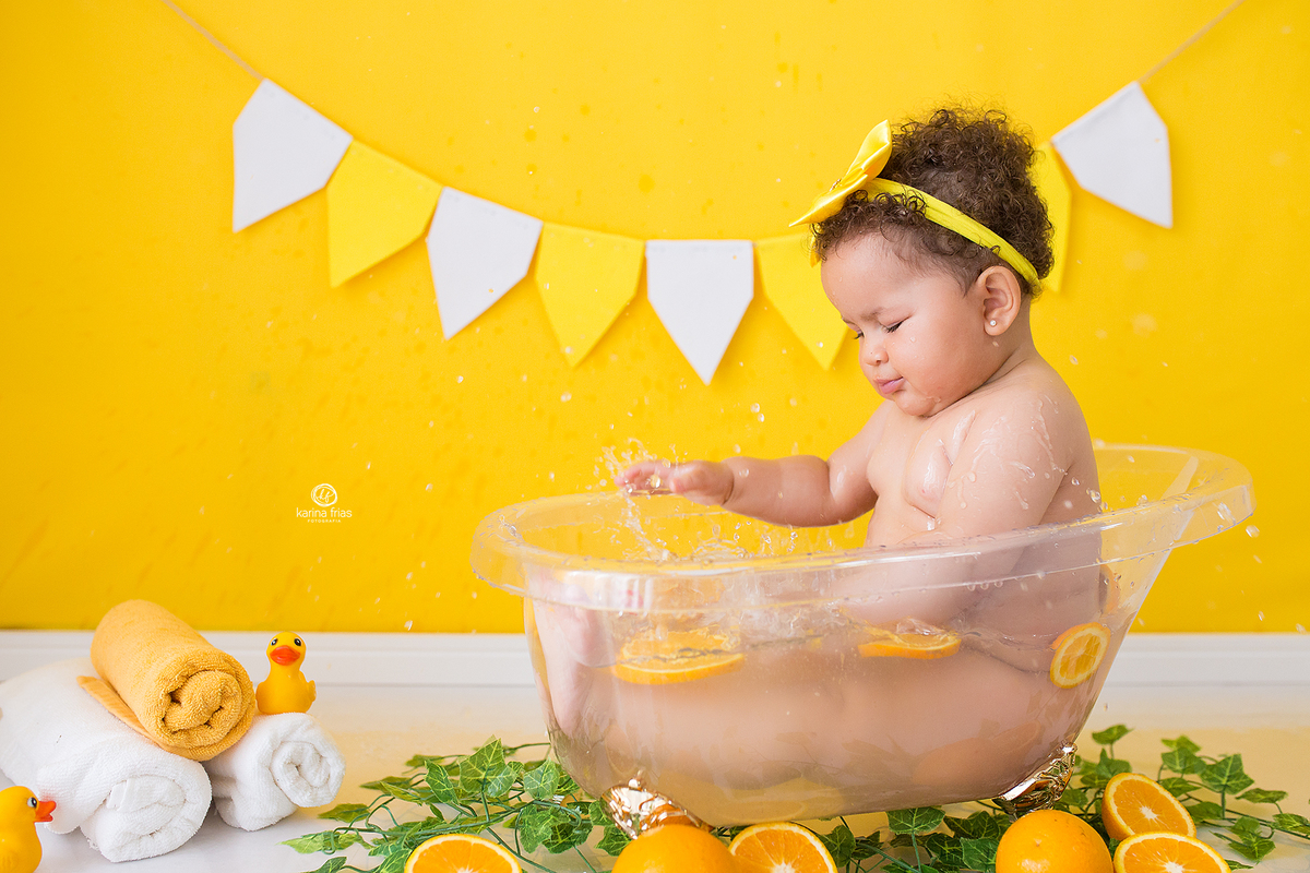 a menina bate na agua durante sessão de fotos infantis