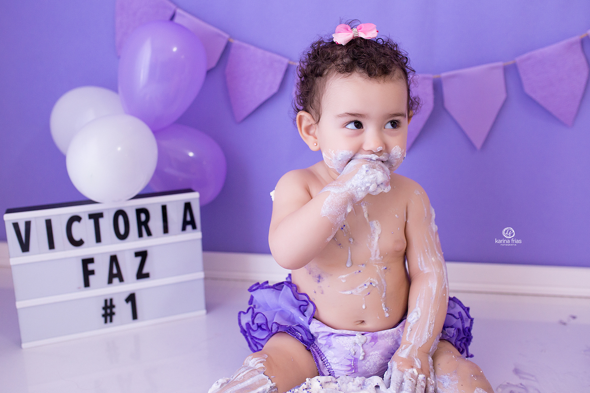 a menina come o bolo durante sessão de fotos