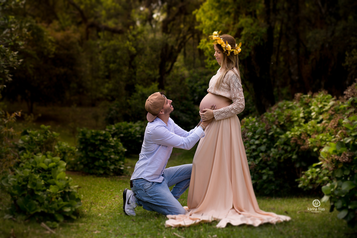 o pai se ajoelha na frente da gestante durante sessão externa