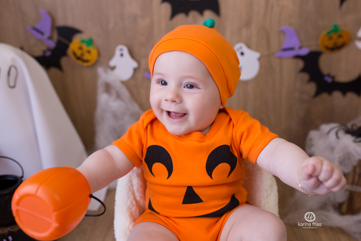 O MENINO ESTA VESTIDO DE ABOBORA PARA AS FOTOS DE HALLOWEEN