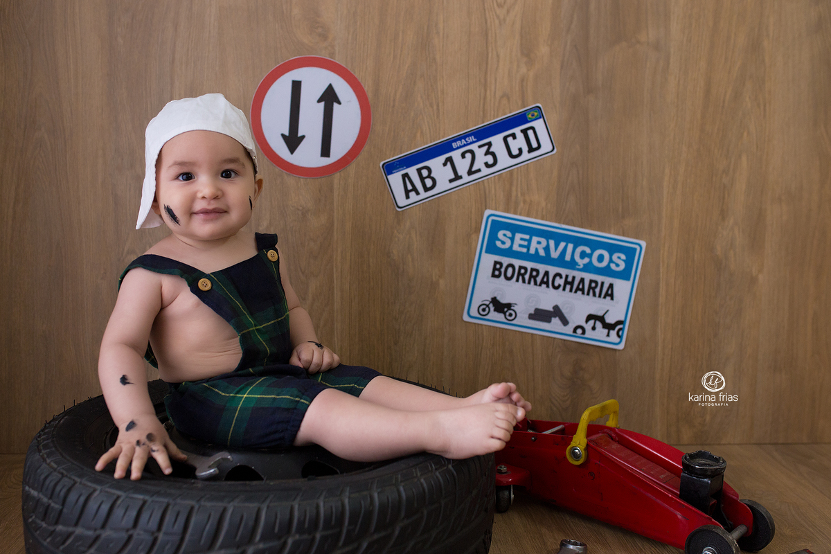 O BEBE ESTA SENTADO NO PNEU PARA AS SUAS FOTOS MENSAIS