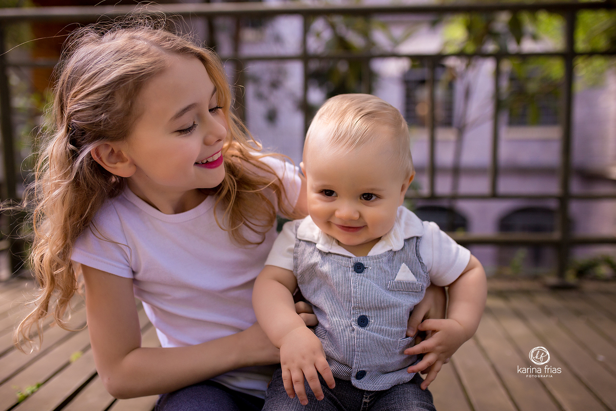 a irmã brinca com o irmão durante a sessão de fotos