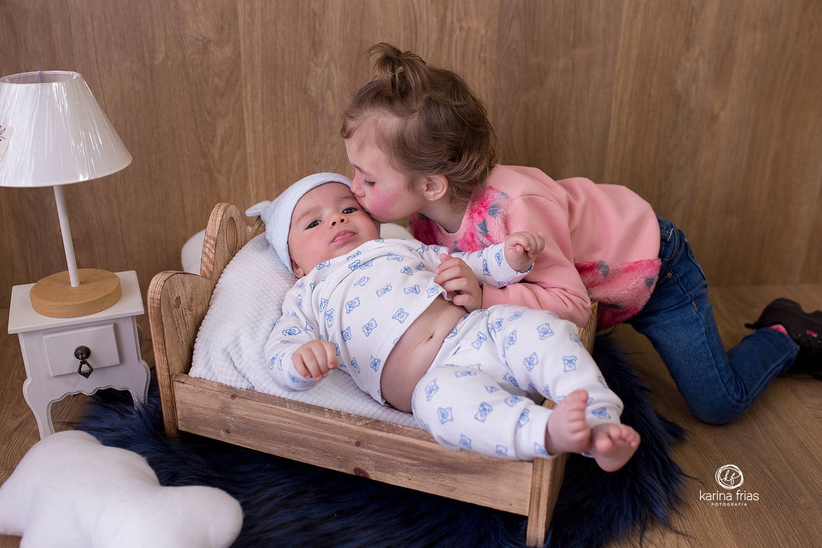 a irma beija a criança no ensaio infantil