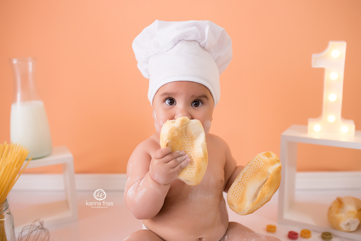 a menina se esconde atrás do pão durante a sessão de fotos