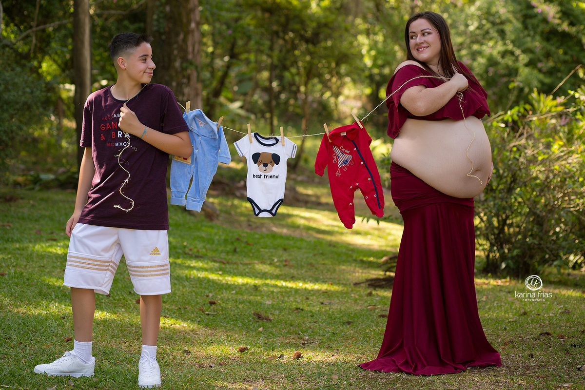MAE E FILHO SEGURAM O VARAL COM AS ROUPAS DO BEBE