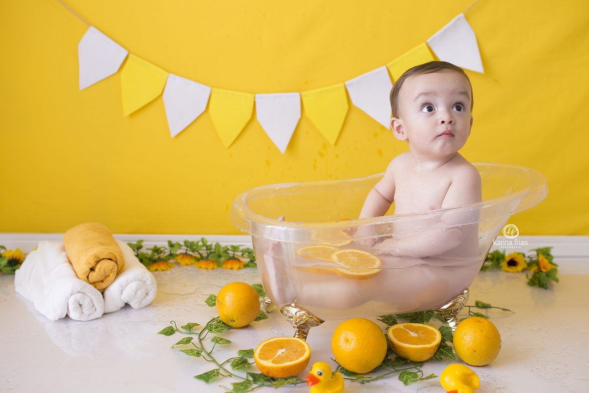 o menino brinca com a laranja no ensaio infantil