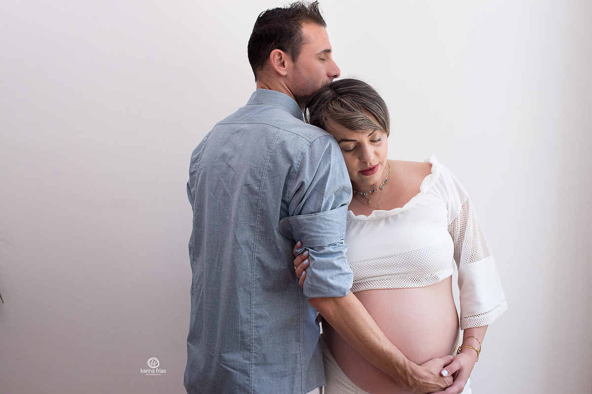 os pais se abraçam par as fotos de gestante