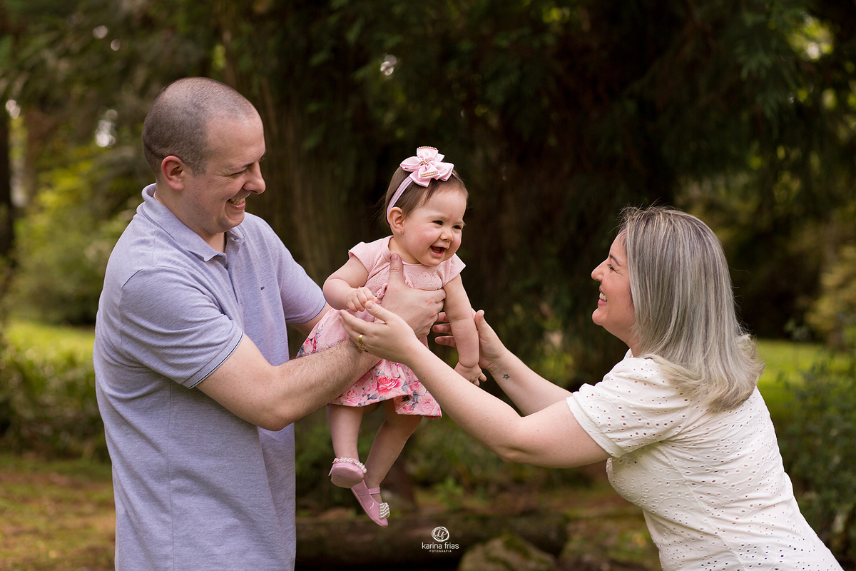 os pais brincam com a filha na sessão de fotos externa