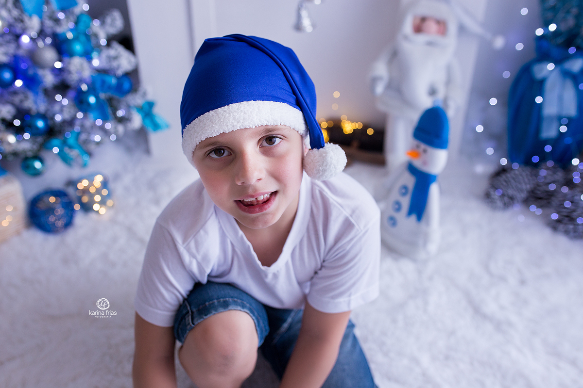 no ensaio de natal o menino olha para a fotografa de familia de caxias do sul, karina frias