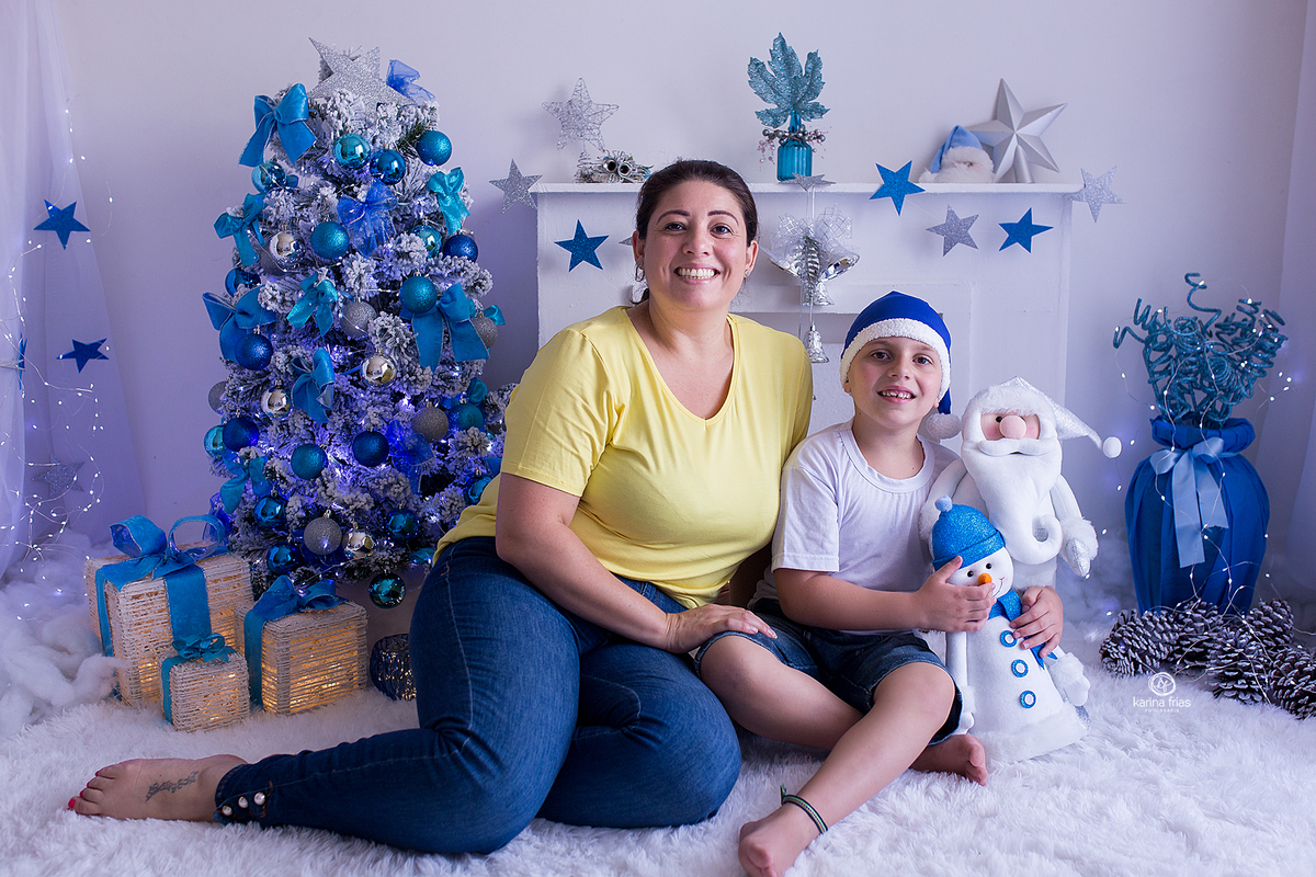 a mae posa com o filho no cenario de natal