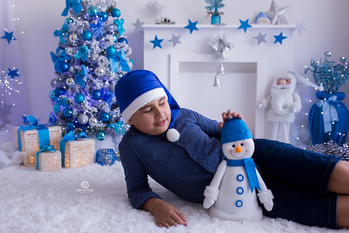 o menino brinca com o boneco na sessão de natal 2020