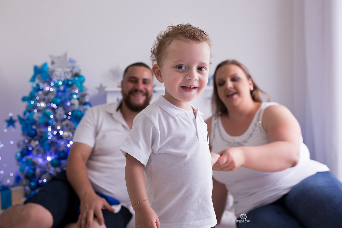 o menino sai de perto dos pais no ensaio de natal