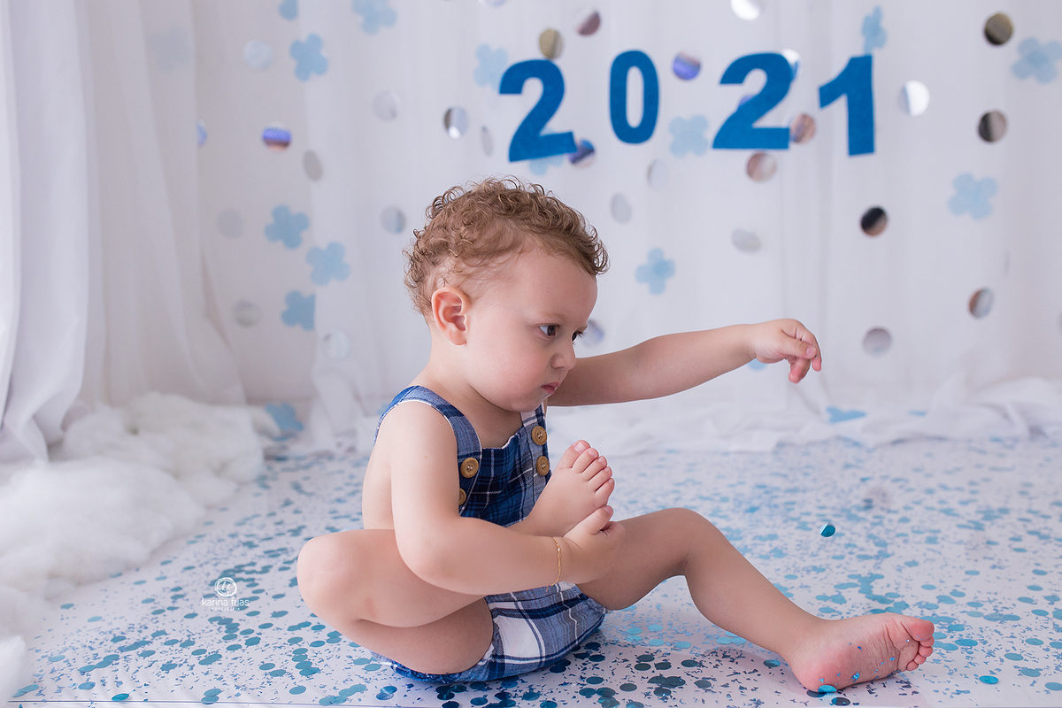 o menino segura o pe na sessão natalina