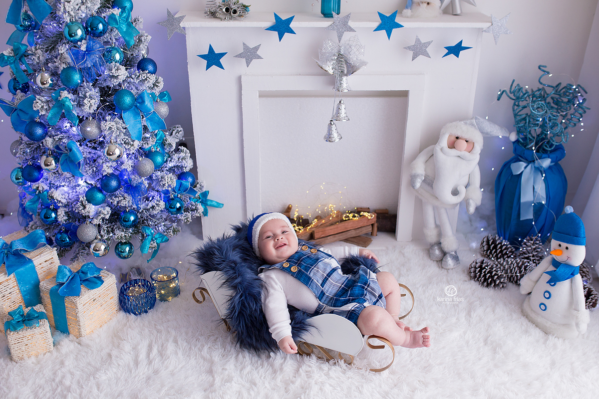 o menino esta deitado no trenó para as fotos de natal 2020