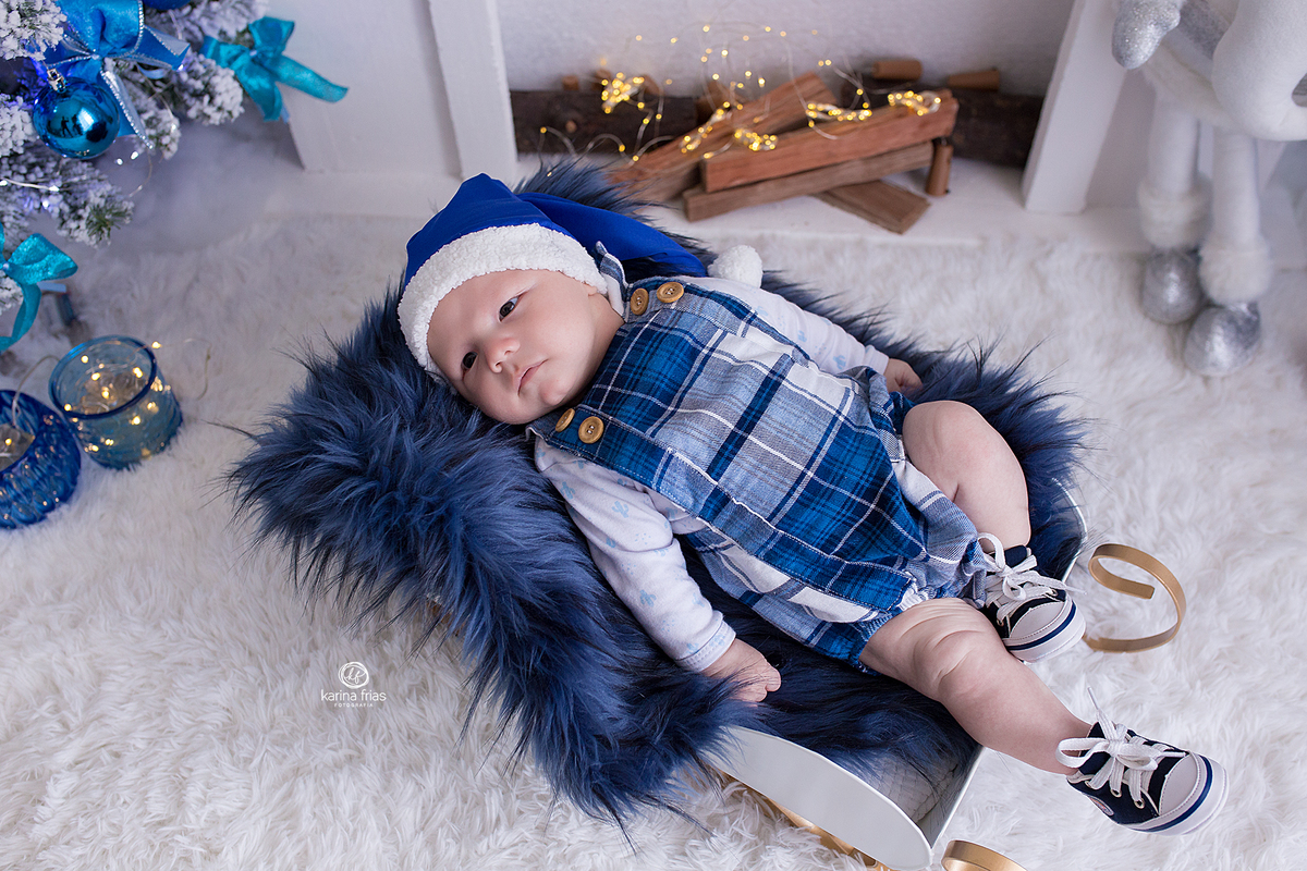 o menino esta deitado no treno do papai noel