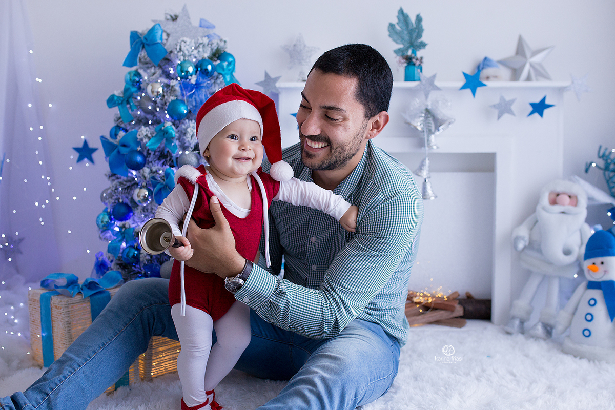 o pai sorri para a filha enquanto a fotografa de bebes de caxias do sul, registra o momento