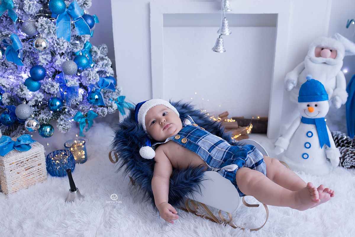o menino esta deitado no treno para as fotos natalinas