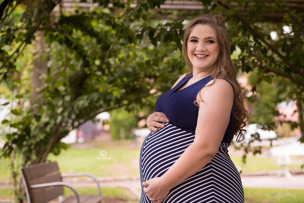 a gestante sorri durante ensaio externo