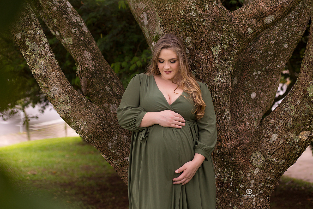 a gestante olha para a barriga durante a sessão 