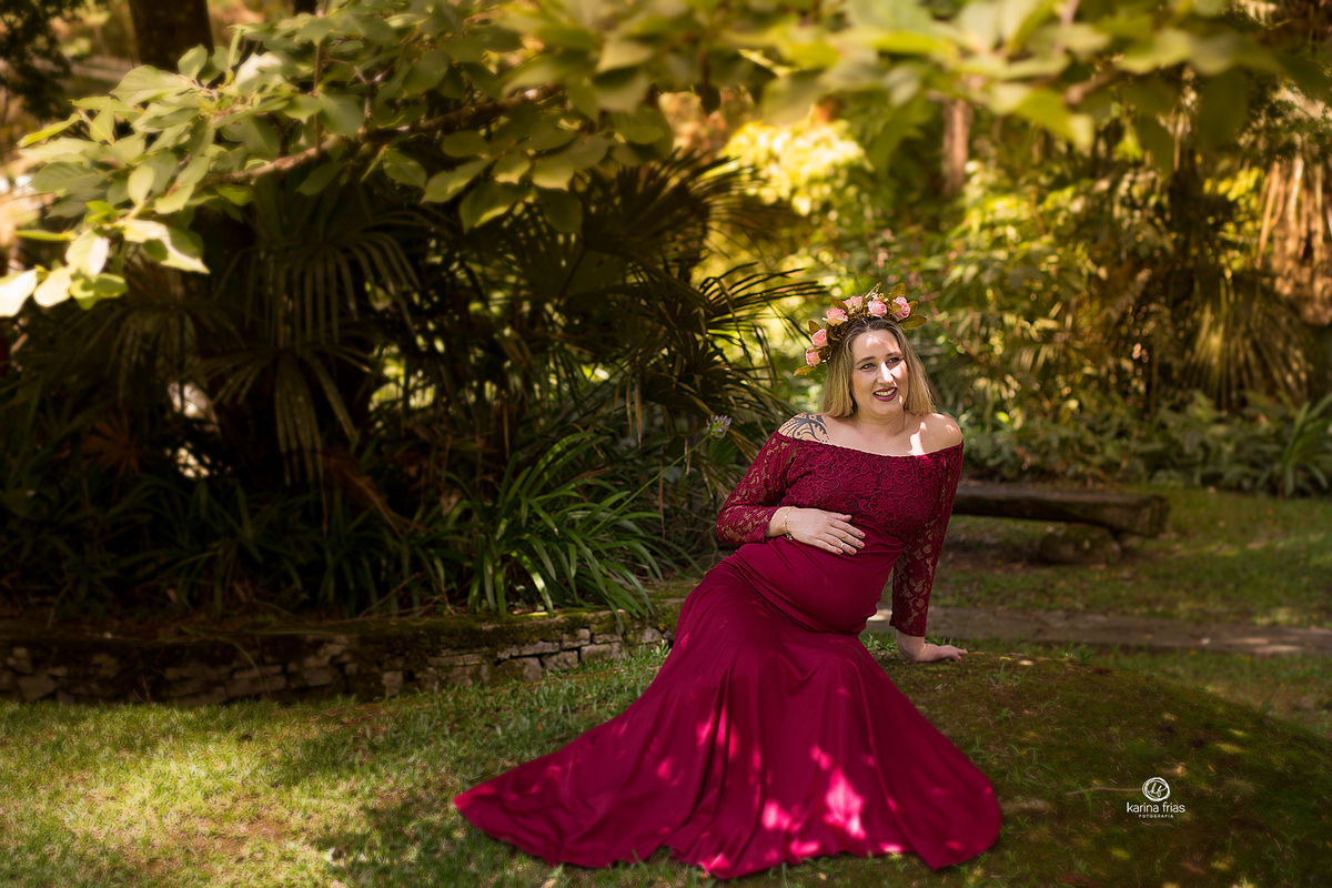 a gestante esta sentada para a sessao de fotos