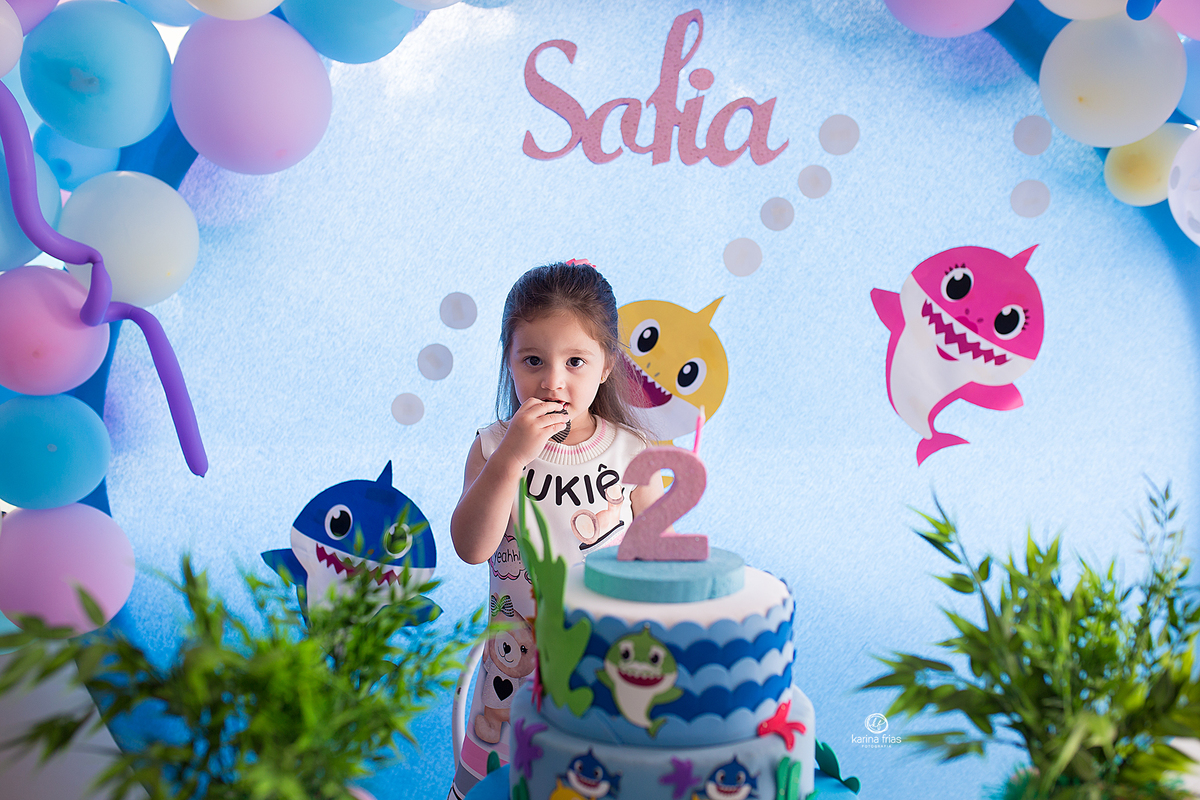 a menina posa na mesa do aniversario infantil