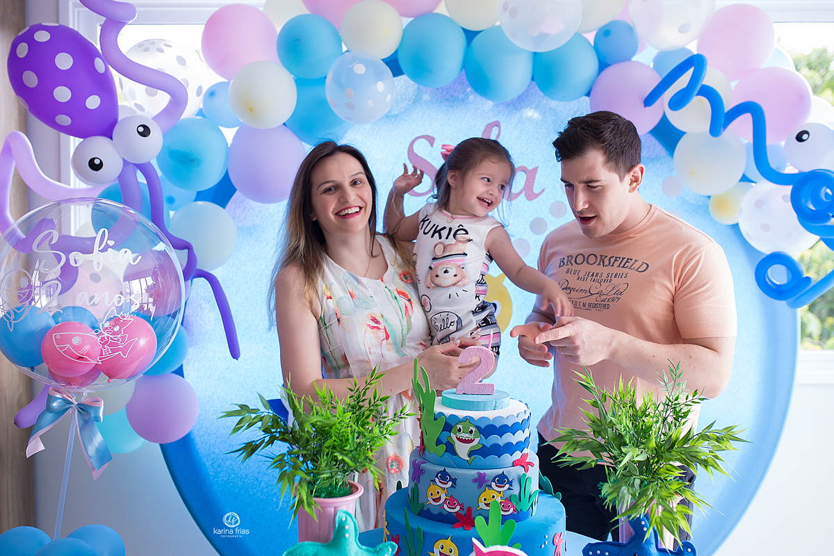 os pais brincam com a filha no aniversario