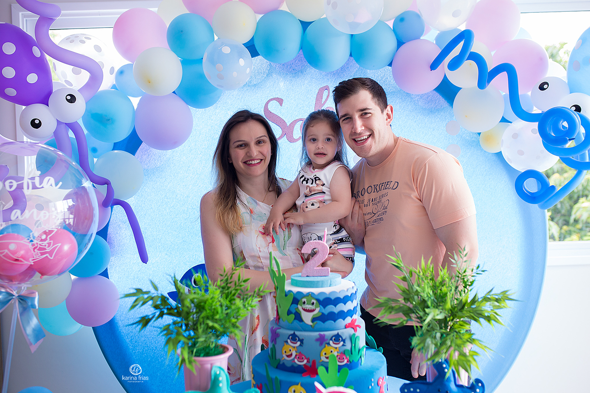 na festa de aniver os pais posam com a filha