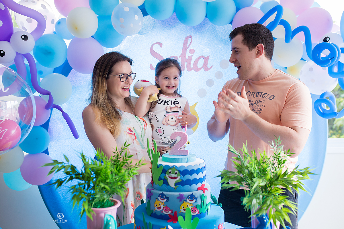 os pais cantam os parabens para a filha na festa