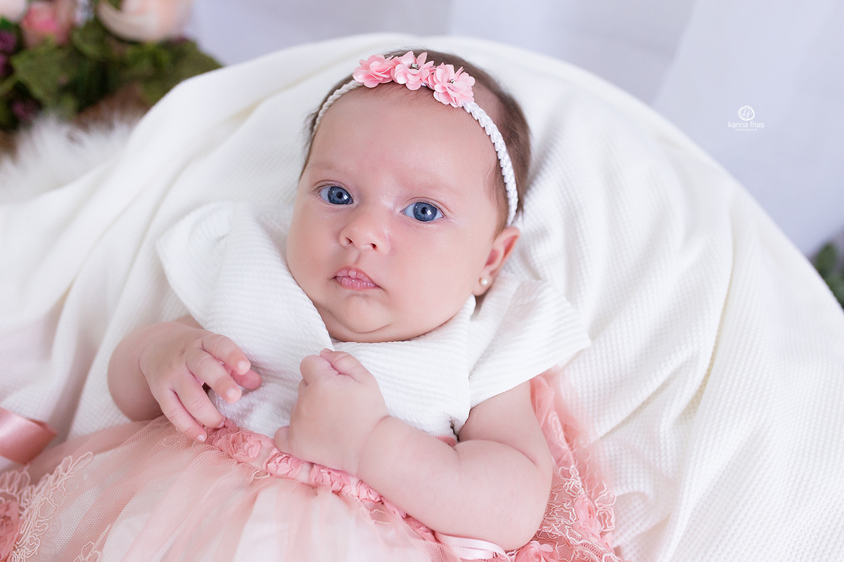 no ensaio infantil a bebe olha para a fotografa de caxias do sul, karina frias