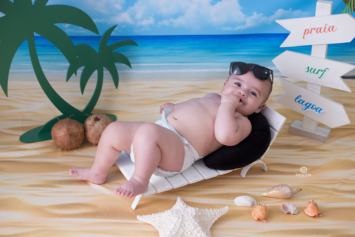 o menino esta deitado na espreguiçadeira do ensaio de verão