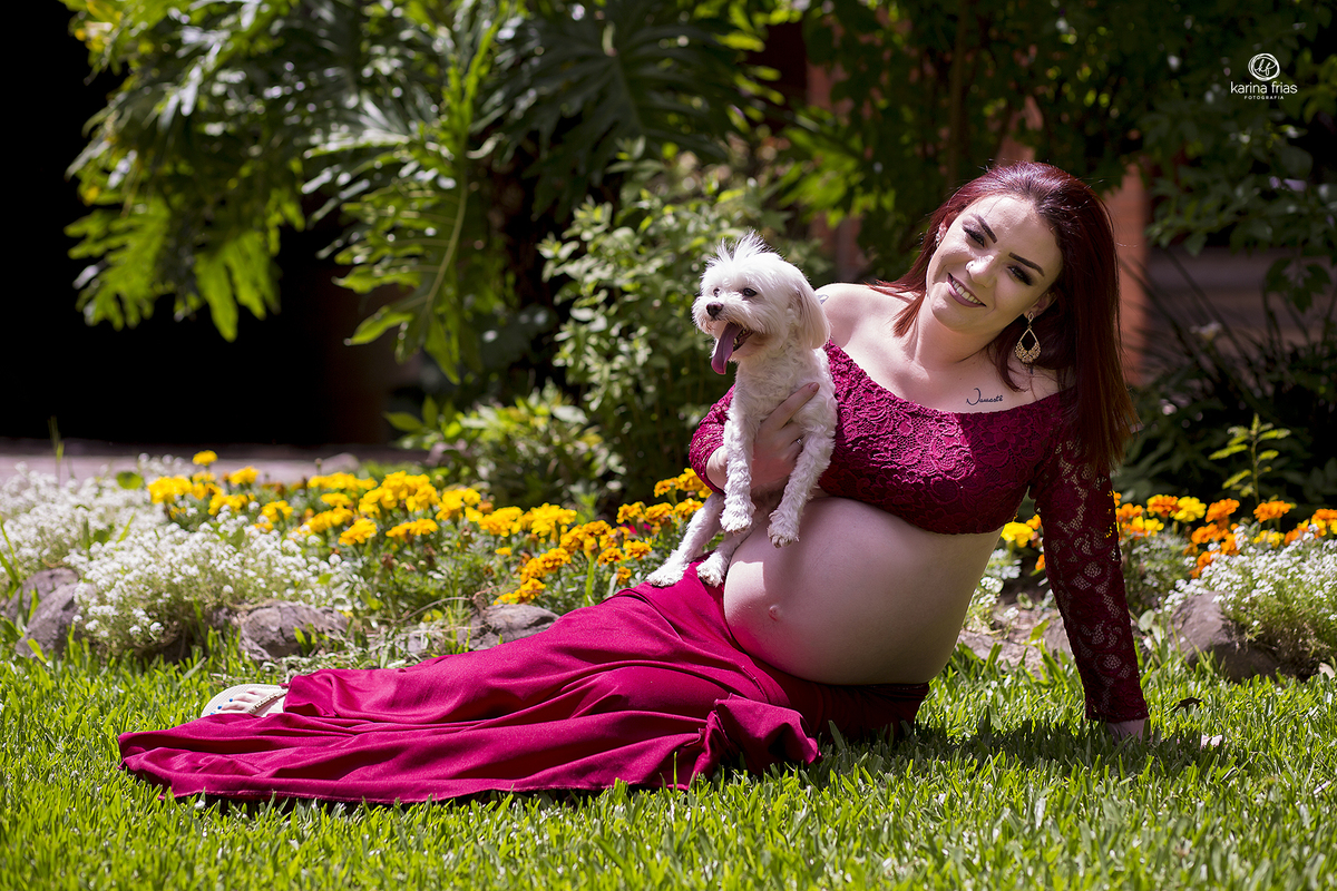 a gestante segura o cachorro durante sessão de fotos