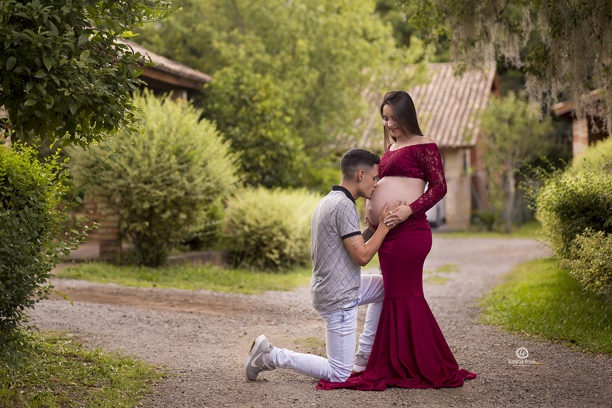 o pai beija a barriga de gestante na sessão de fotos