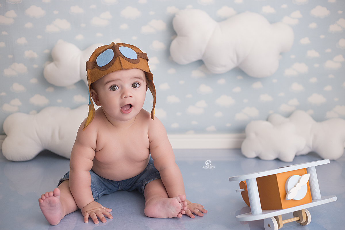 o menino esta vestido de aviador para as fotos de acompanhamento mensal