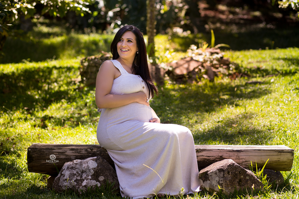 a gestante esta sentada para suas fotos externas