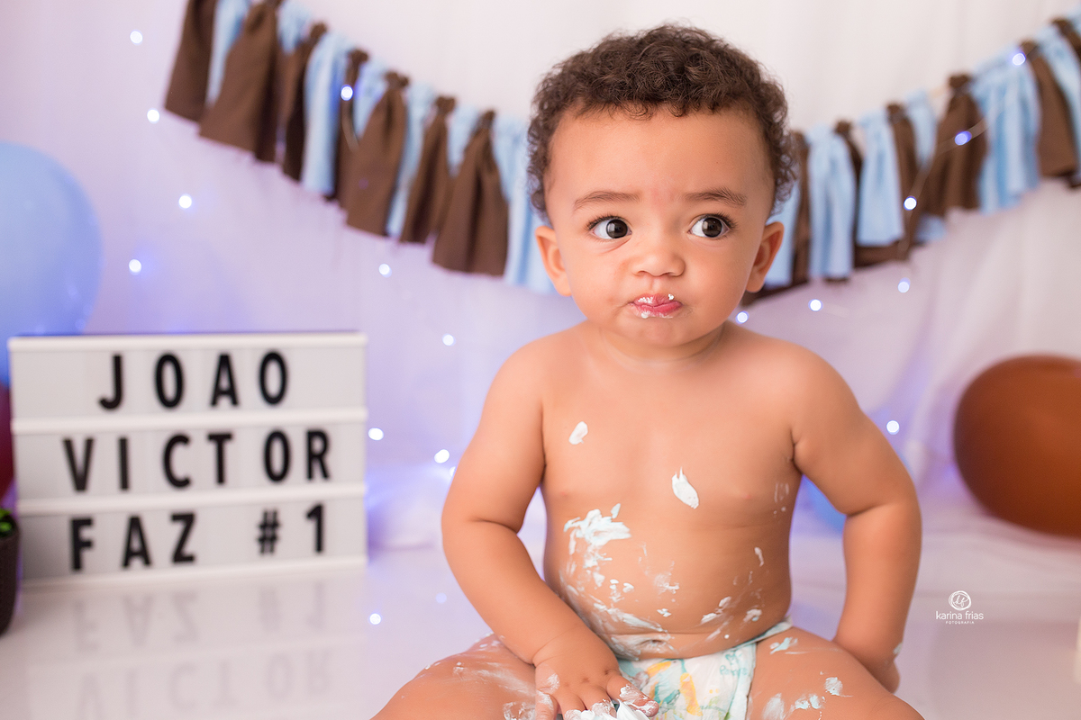 no ensaio infantil com o bolo o menino esta comendo