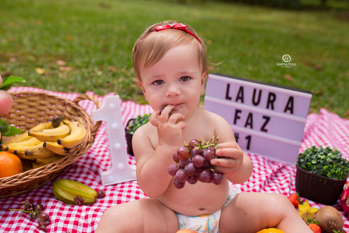 a menina come uvas na sessão fotografica